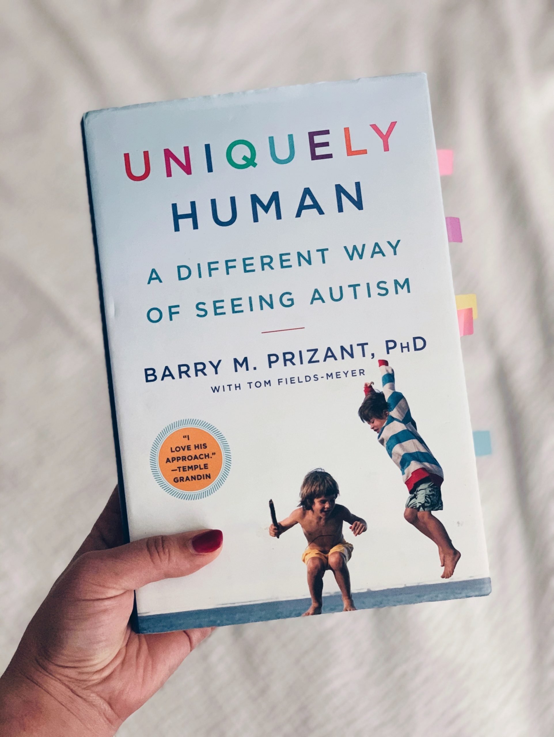 Hand holding book, Uniquely Human - Barry M. Prizant, PhD