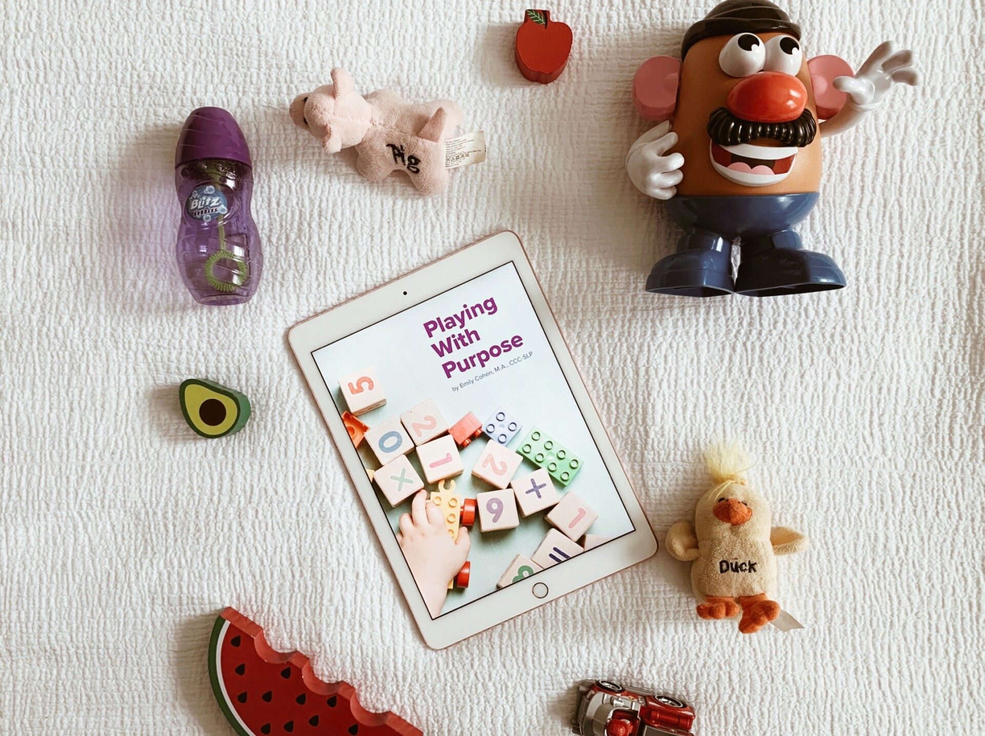 toys and ipad on bed